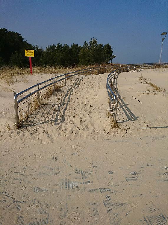 Kładka wzdłuż wydm pełna piasku, niczym plaża. Czytelniczka przesłała zdjęcie