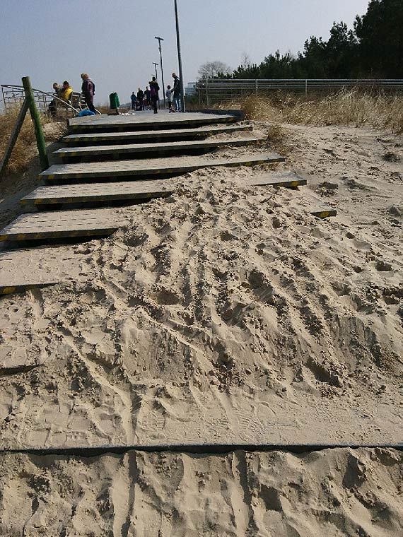 Kładka wzdłuż wydm pełna piasku, niczym plaża. Czytelniczka przesłała zdjęcie