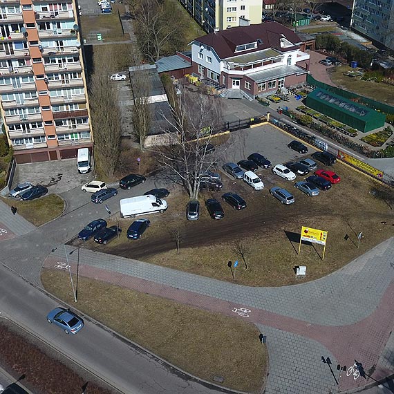 Rozjedony trawnik przy sklepie ogrodniczym suy jako parking