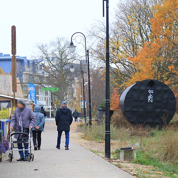 Bd tnie i wodny zegar soneczny. Wykonawca wchodzi na zabytkow promenad