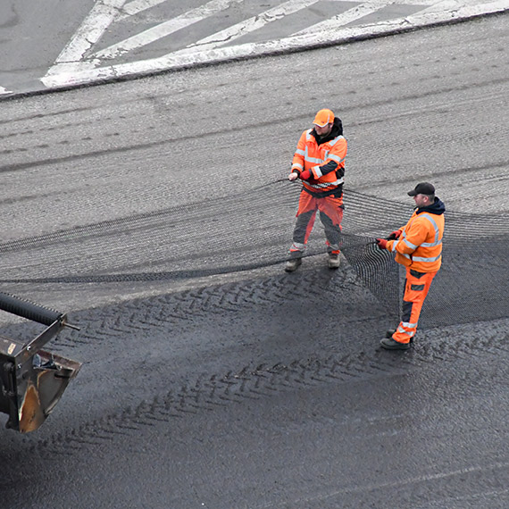Siatka pod asfaltem na ulicy 11 Listopada. To nie gad�et, tylko technologia, kt�ra ma op�nia� p�kanie nawierzchni